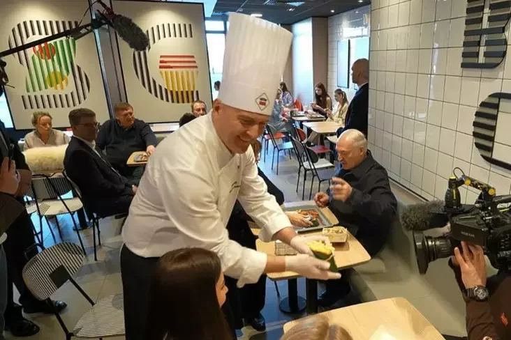 Łukašenka naviedvaje restaran Mak.by. Za stolikam źleva siadziać Śviatłana Kanašenka, Uładzimir Kucharaŭ, Siarhiej Ciacieryn i Mikałaj Snapkoŭ, na stale lažyć špic Umka. Minsk, 8 sakavika 2026 hoda. Fota: pres-słužba Alaksandra Łukašenki